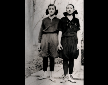 Two girls posing in their new basketball uniforms in 1921. The bloomers are made up with at least 5 yards of fabric.